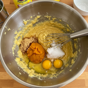 Mixing pumpkin banana muffin batter with wet ingredients.