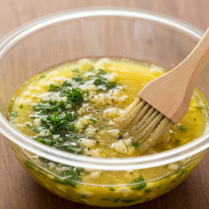 Garlic butter spread being prepared with fresh herbs and melted butter.