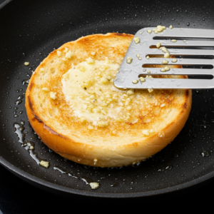 Golden toasted burger buns with garlic butter in a skillet