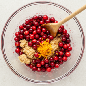 Fresh cranberries, sugar, and orange zest mixed for a homemade sauce.